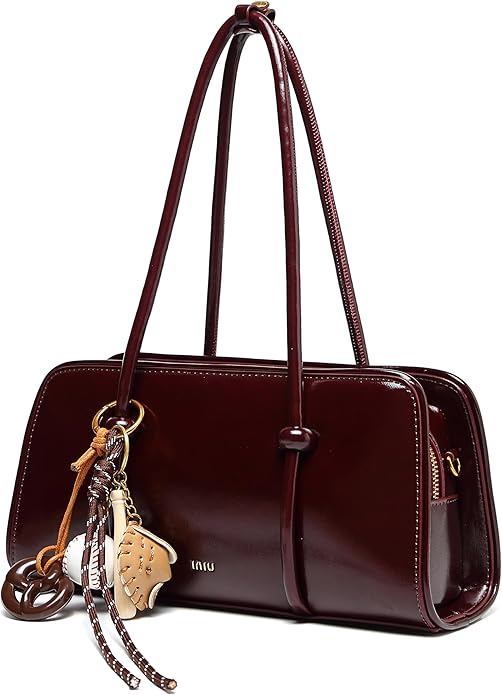 Brown handbag with decorative keychain on a white background